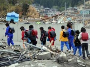 Ici à Otsuchi, des écoliers reviennent de l'école et rentrent dans leur camp d'hébergement « provisoire ». AFP PHOTO / TOSHIFUMI KITAMUR